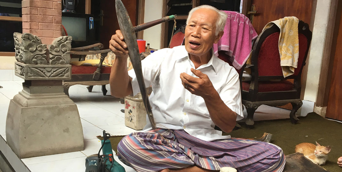 An older man holds a piece of the boat 