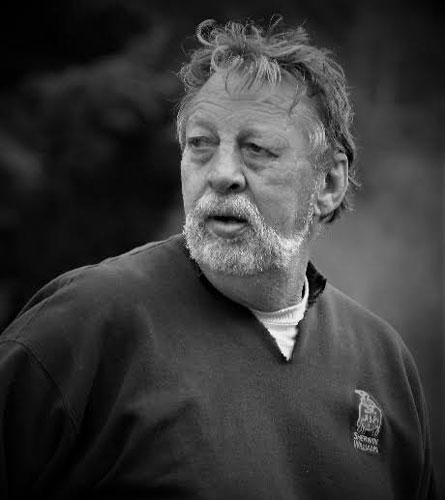 a black and white photo of a man with a white beard and mustache, looking away from the camera