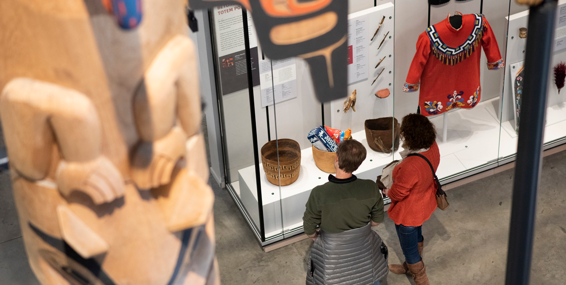 two visitors in the nwna gallery, photographed from the floor above